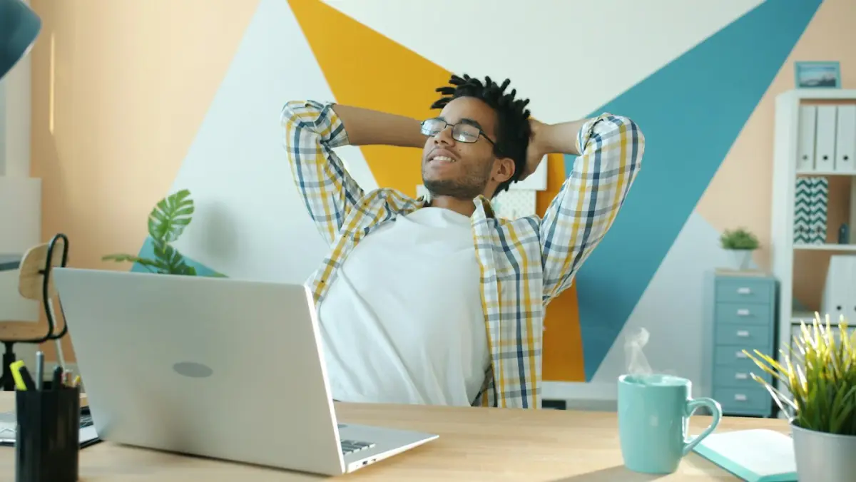 A man leaning back from his laptop, relaxed