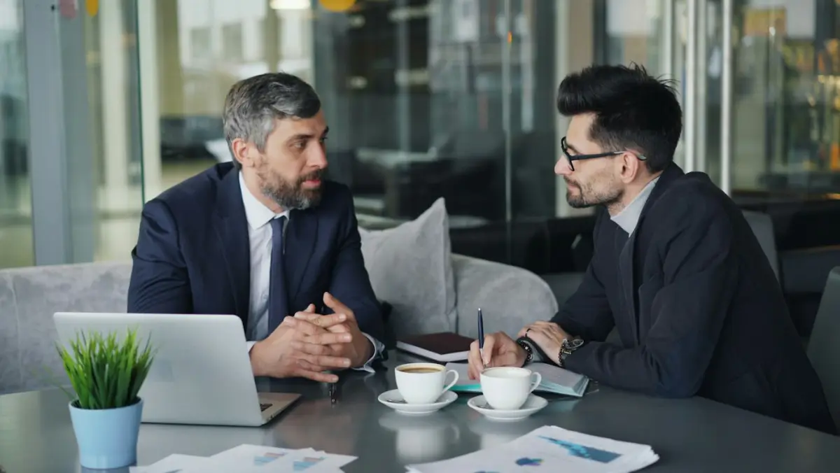 Two men in conversation across a café table