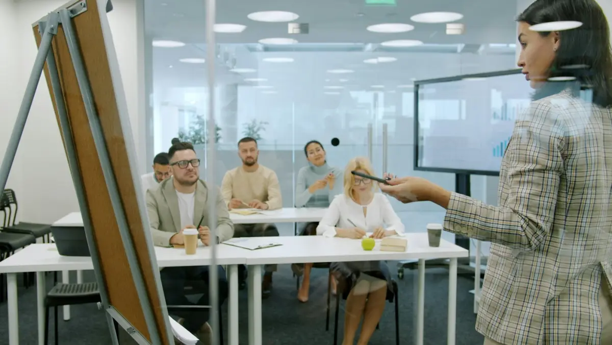 A woman presenting to colleagues in a meeting room